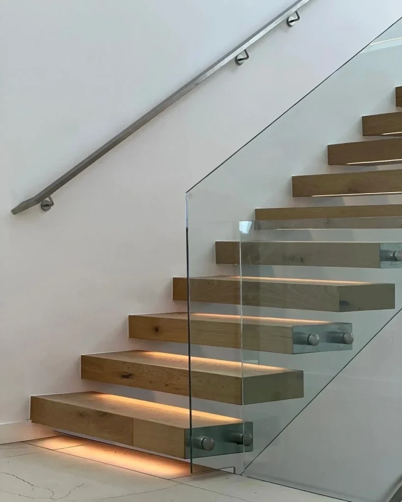 Floating wood stairs with frameless glass railing, stainless handrail, and integrated LED lighting in Lakewood, WA