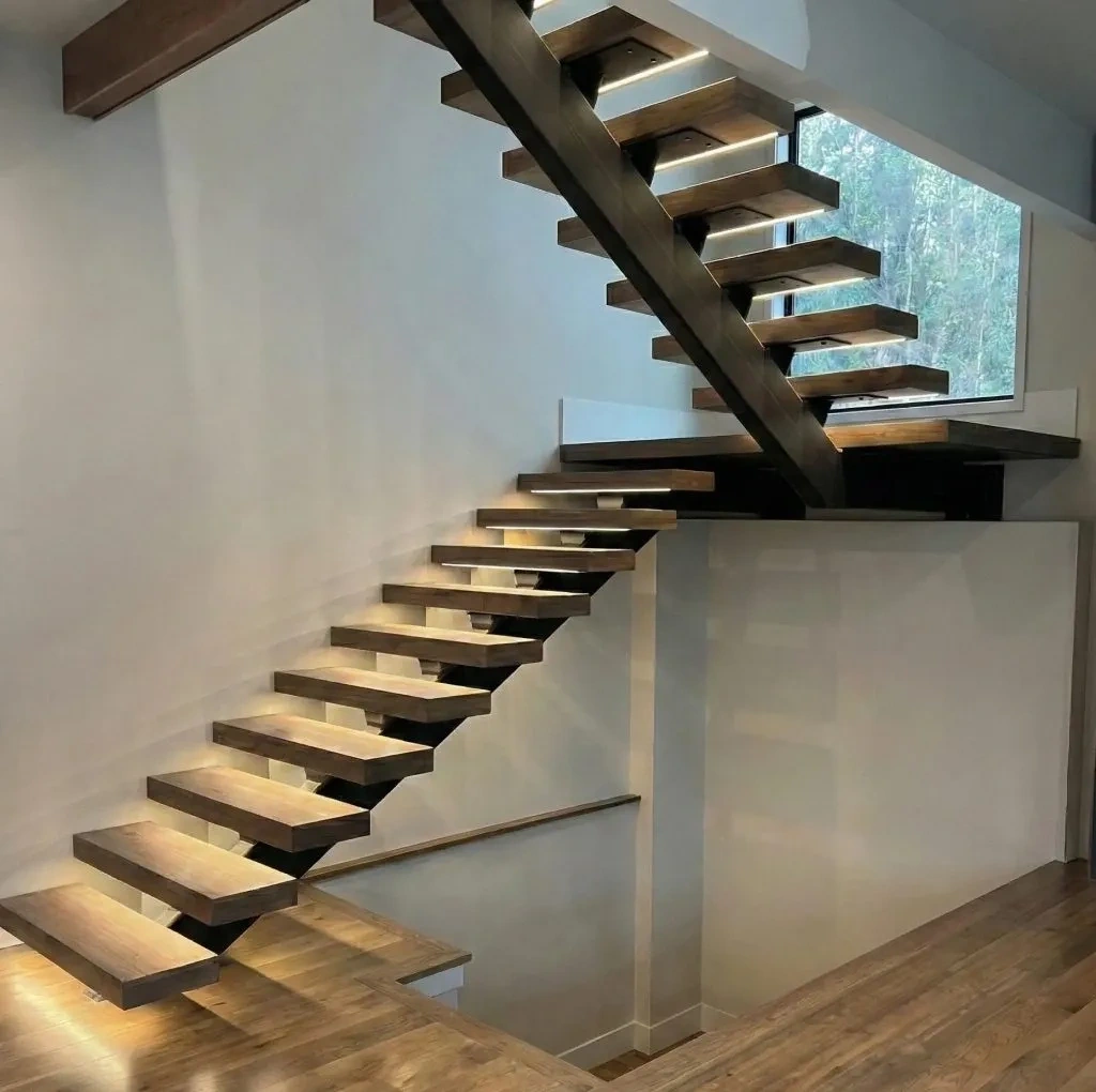 Illuminated mono-stringer floating staircase with wood treads and central black steel support in Everett, WA